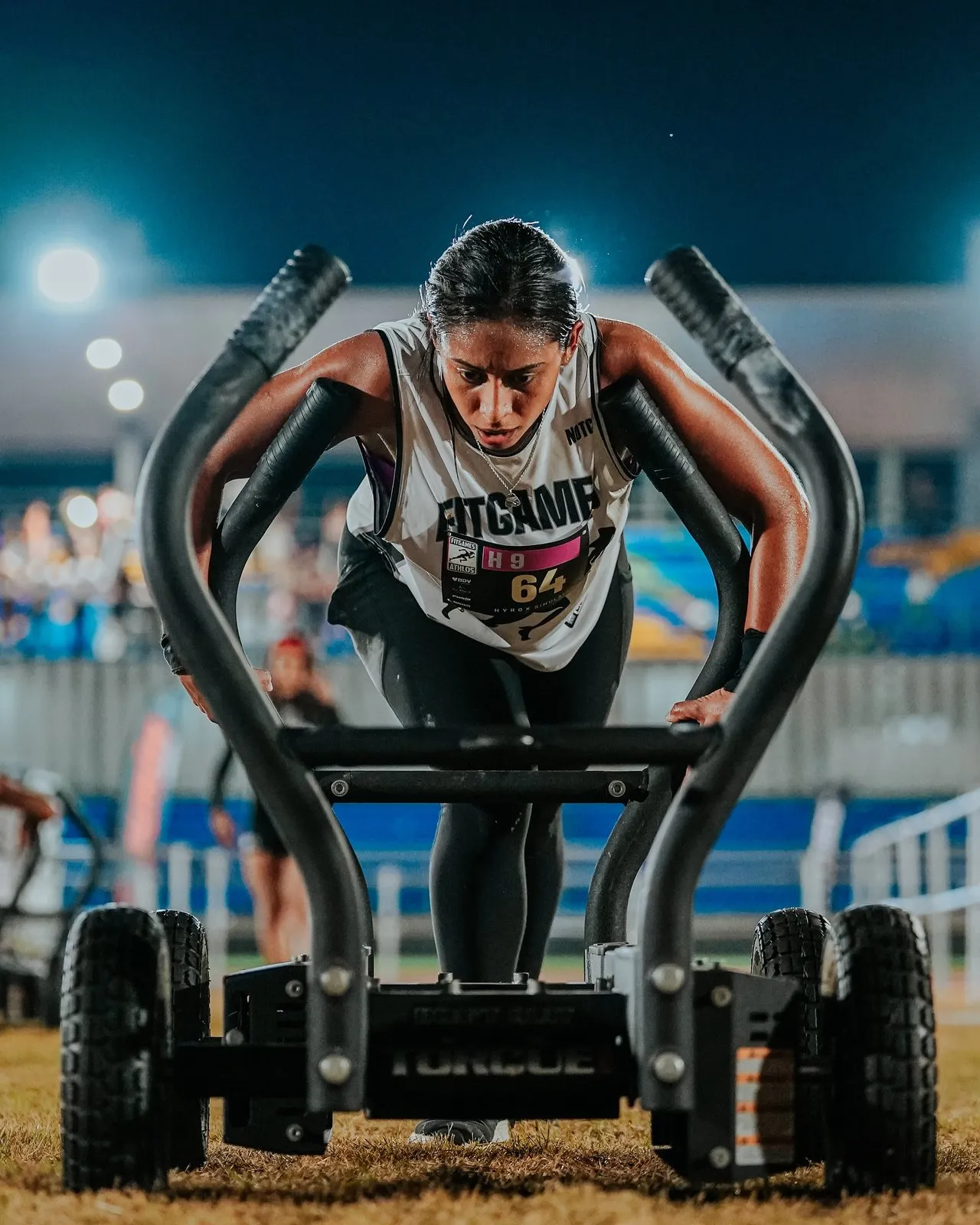 Atleta de Athlos empujando un trineo